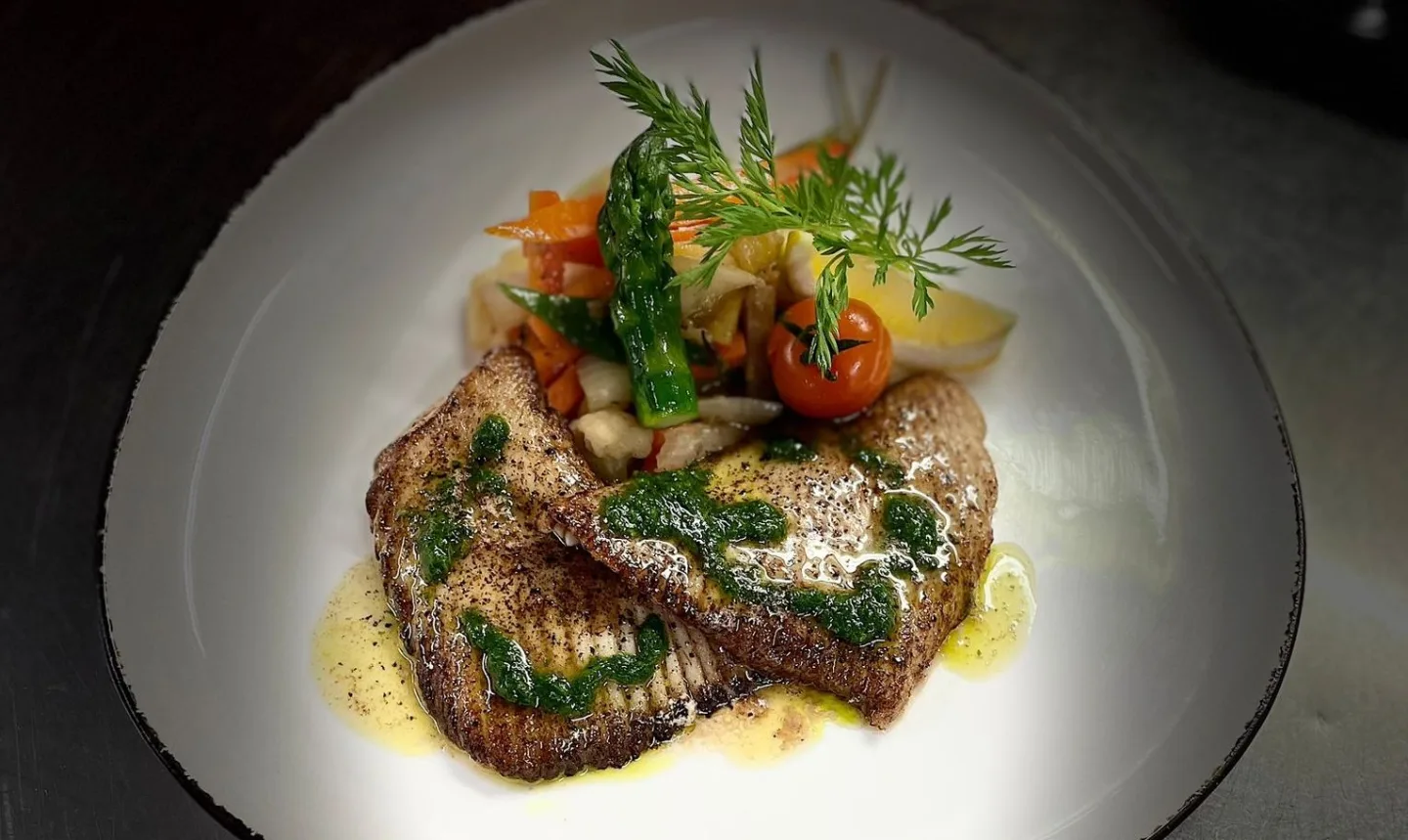 Filet de poisson rôti aux herbes fraîches, dressé à l’assiette.